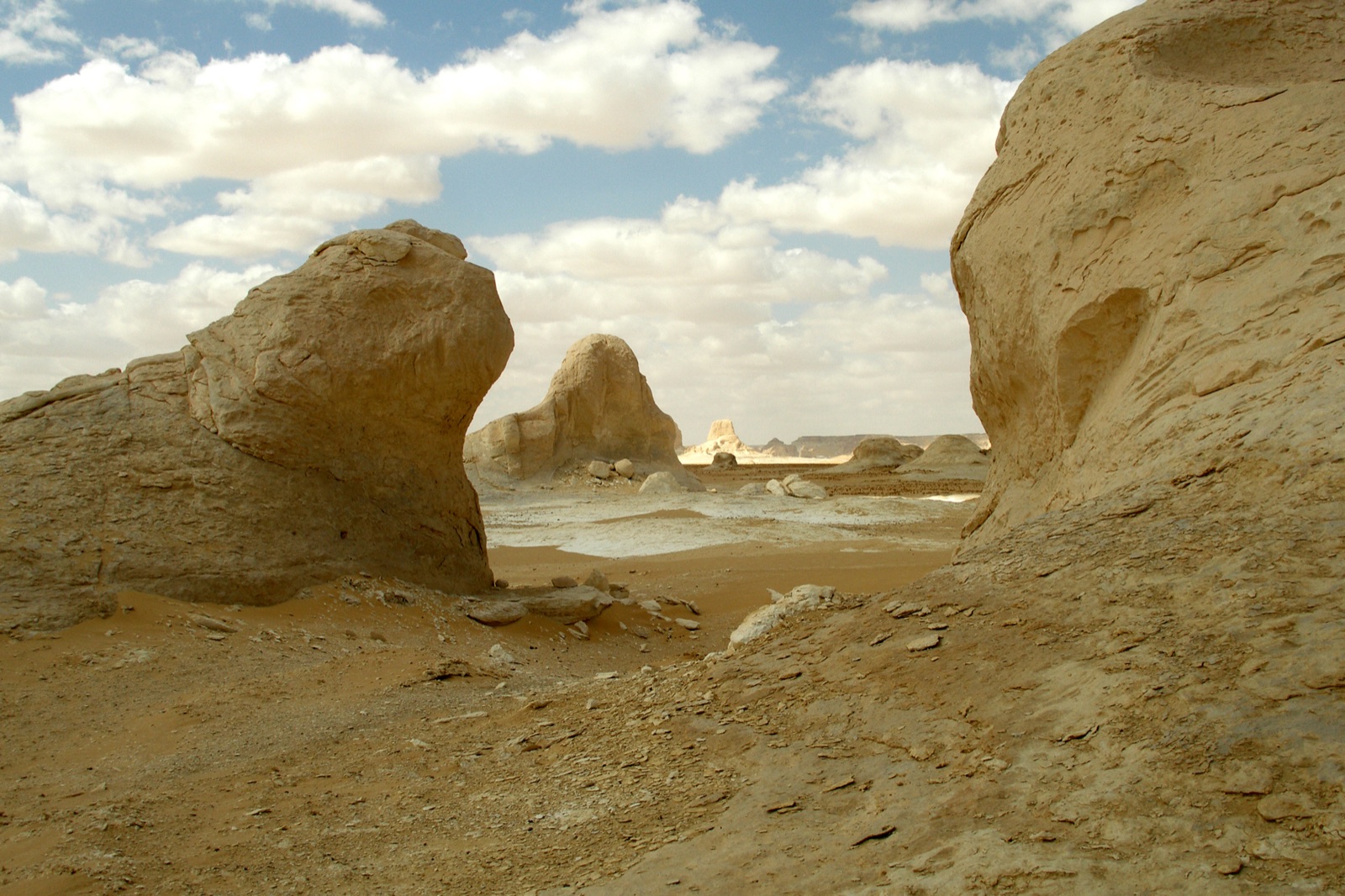 Pale chalk formations rising from open ground in Egypt's White Desert